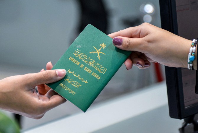 A Saudi woman receives her newly-issued passport at the Immigration and Passports Centre in the capital Riyadh on August 29, 2019. Saudi Arabia has eased travel restrictions on women, allowing those aged over 21 to obtain passports without seeking the approval of their "guardians" - fathers, husbands or other male relatives, but observers say loopholes still allow male relatives to curtail their movements and, in the worst cases, leave them marooned in prison-like shelters. (Photo by FAYEZ NURELDINE / AFP)